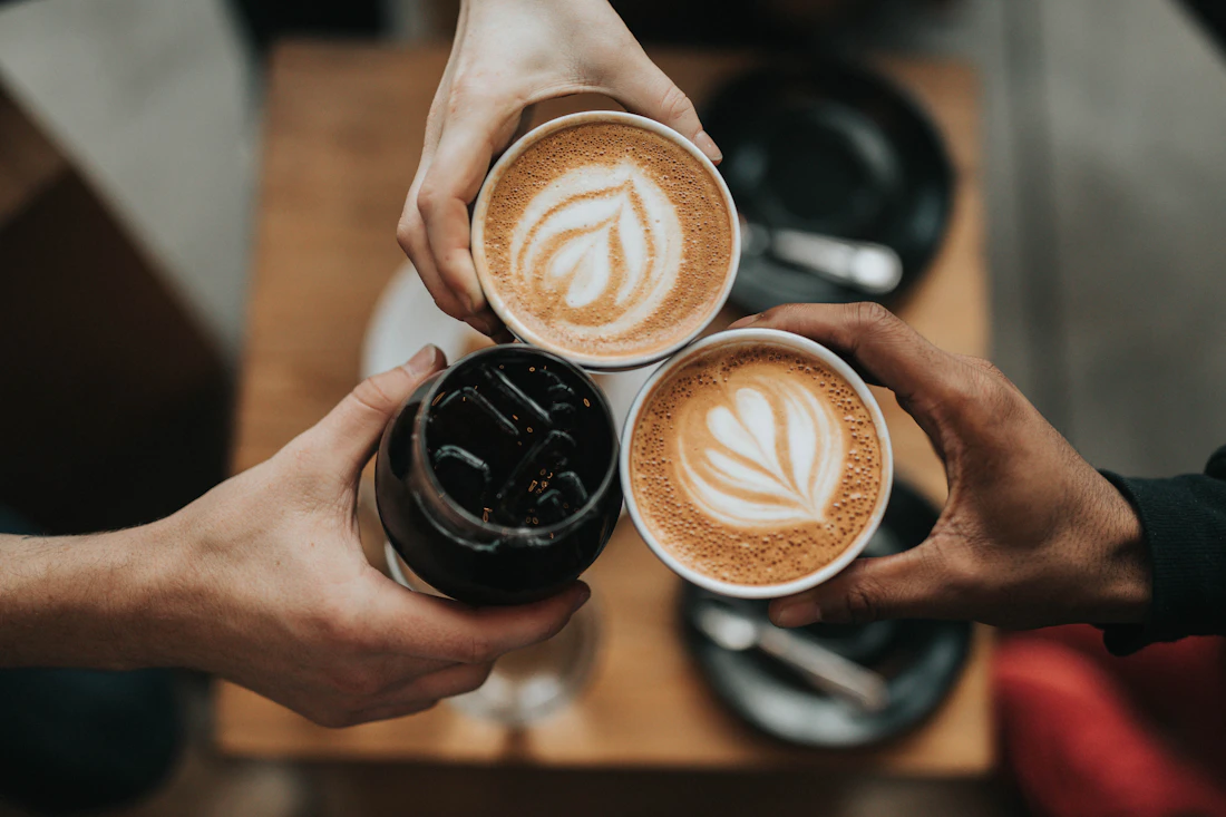 コーヒーカップを持ち寄って乾杯する3人の手元